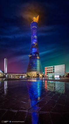 a very tall building sitting in the middle of a large body of water at night