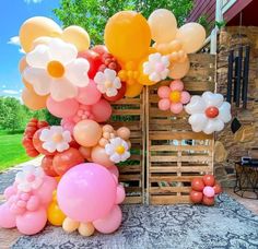 an outdoor area with balloons and flowers on the ground