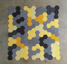 a crocheted rug made to look like hexagons on cement floor