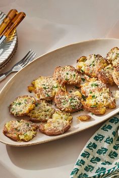 a white plate topped with potatoes covered in cheese and parmesan sprinkles