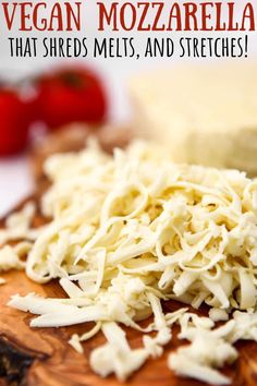 a wooden cutting board with shredded cheese on it and the title vegan mozzarella that shreds, melts, and stretches