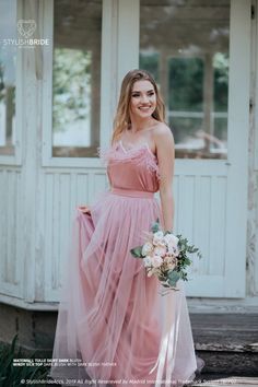 a woman in a pink dress holding a bouquet