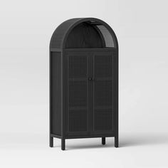 a black cabinet with an arched door on the top and bottom, in front of a white background