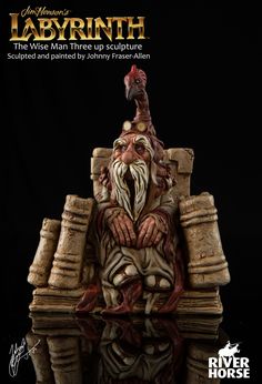 a statue of an old man with a rooster on his head sitting in front of a black background