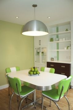 a dining room table with green chairs around it