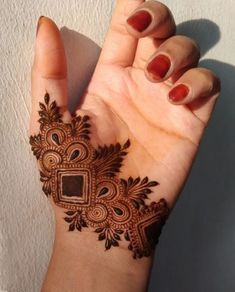 a woman's hand with a henna tattoo on it