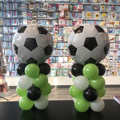 two soccer balls and some balloons on a table