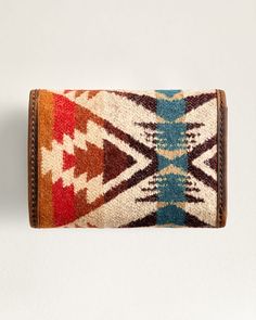 This trifold wallet features a snap closure, ID window, coin pocket, and multiple card slots, providing ample space for all your essentials. With the added protection of RFID technology, your personal information stays safe and secure. Made with Pendleton USA wool in a unique pattern and finished with leather trim, each wallet is one-of-a-kind. Please note that pattern placement may vary. Loving the Pasco Design? Check out the additional matching bags. Pasco Trifold Wallet: Size Closed: 3"W x 4 1/2;"H x 1/2" 100% pure virgin wool; cotton trim Wool fabric woven in Pendletons American mills. Care: Spot clean. No sales tax. Check out our Facebook Photos and Instagram to find fun and inspirational ideas for decorating any space. Vintage Trifold Wallet With Rfid Blocking, Vintage Trifold Wallet With Interior Card Slots, Brown Trifold Coin Purse For Travel, Vintage Trifold Wallet For Everyday Use, Vintage Multicolor Travel Wallets, Brown Trifold Wallet For Travel, Pendleton Decor, Pendleton Bag, Pendleton Flannel