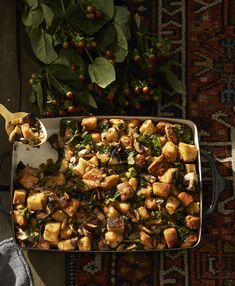 a pan filled with stuffing and vegetables on top of a rug