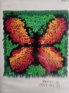 an image of a butterfly made out of crochet on green grass with flowers