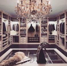 an open closet with a chandelier hanging from the ceiling