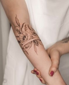 a woman's arm with flowers on it and the words enregiste written in