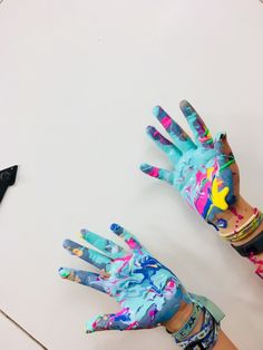 two children's hands painted with different colors