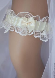 a white garter with a bow on it's side and lace around the waist