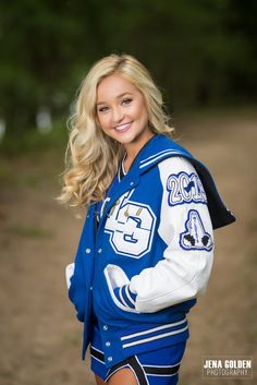 a beautiful young blond woman wearing a blue and white cheerleader uniform posing for a photo