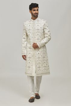 White sherwani with thread floral embroidery all-over and welt pocket in front. Comes with churidar.
Components:2
Pattern:Embroidery
Type of Work:Thread
Neckline:Mandarin Collar
Sleeve Type:Long
Fabric:Silk and Art Silk
Color:White
Other Details:
Closure: Button front
Note: 
Pocket square worn by the model is not for sale
The fabric is silk blend and not pure silk
Occasion:Groom - Aza Fashions Designer Sherwani With Intricate Embroidery And Straight Kurta, Diwali Sherwani With Intricate Embroidery, Designer Wear Resham Embroidered Straight Sherwani, Embroidered Jamawar Bandhgala With Traditional Drape, Diwali Sherwani With Intricate Embroidery In Jamawar, Diwali Jamawar Sherwani With Intricate Embroidery, Festive Sherwani With Intricate Embroidery In Straight Kurta Style, Festive Sherwani With Intricate Embroidery On Straight Kurta, Festive Sherwani With Intricate Embroidery And Straight Kurta Shape