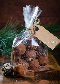 a bag full of chocolate truffles sitting on top of a wooden table next to a pine tree