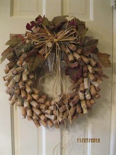 a wreath made out of wine corks hanging on a door with the words, diy