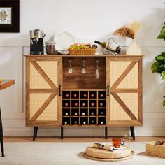 a wooden cabinet with wine glasses and bottles on it in a room next to a potted plant