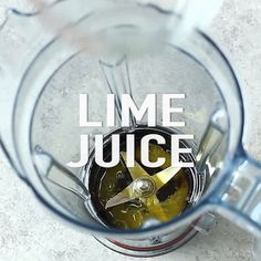 a blender filled with liquid sitting on top of a white counter next to the words lime juice