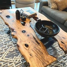 a wooden table with a bowl on it in front of a couch and coffee table