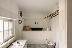 a kitchen with white walls and flooring next to a window