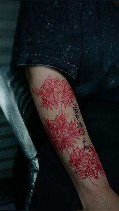 a person with a red flower tattoo on their arm