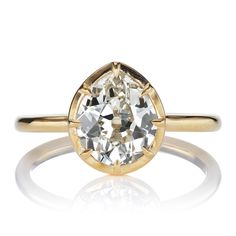 a yellow gold ring with an oval cut diamond in the center, on a white background