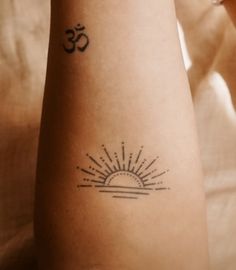 a woman's arm with a tattoo on it that reads om and the sun