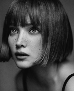 a black and white photo of a woman with freckles on her face