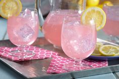 two glasses of pink lemonade sit on a tray