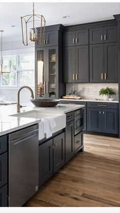 a large kitchen with gray cabinets and white counter tops