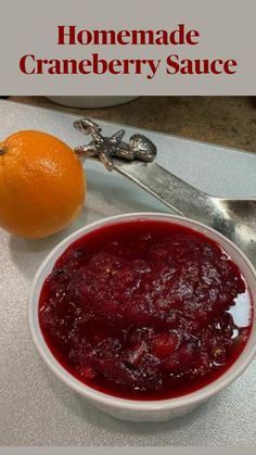 a bowl of cranberry sauce next to an orange