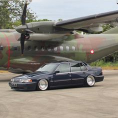 a car parked in front of an airplane