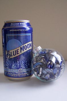 a can of blue moon beer next to an ornament filled with silver bells