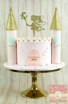 a pink and gold princess castle cake sitting on top of a metal stand with glitter decorations