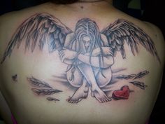 an angel tattoo on the back of a woman's shoulder