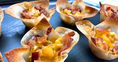 small cups filled with bacon and cheese on top of a black tray next to an oven