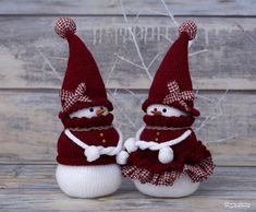 two knitted snowmen wearing red and white outfits