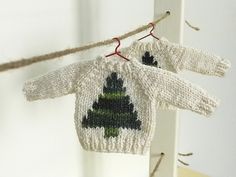 two knitted sweaters hanging from a clothes line