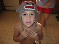 a young boy wearing a crocheted sock monkey hat