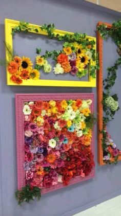 the wall is decorated with flowers and greenery in different colors, including oranges, yellows, and pinks