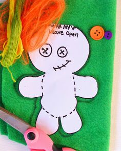 the scissors are next to a cut out of a teddy bear with orange hair on it