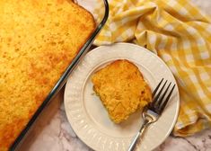 a white plate topped with a piece of cake next to a yellow and white checkered cloth