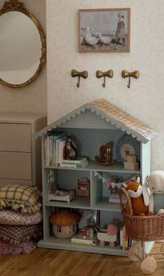 there is a doll house in the corner of this child's room with toys