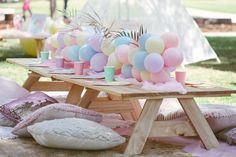 a picnic table with balloons and pillows on it