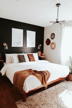 a large bed sitting in a bedroom on top of a wooden floor next to a window