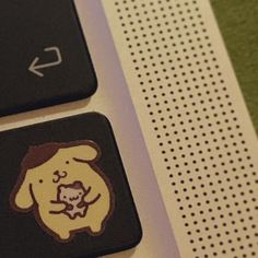 a computer keyboard with a sticker on it's left side and an image of a dog holding a skull in its mouth