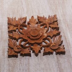 an intricate wooden carving with flowers and leaves