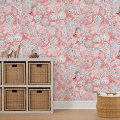 a pink wallpaper with blue and white flowers in the corner next to a wicker basket